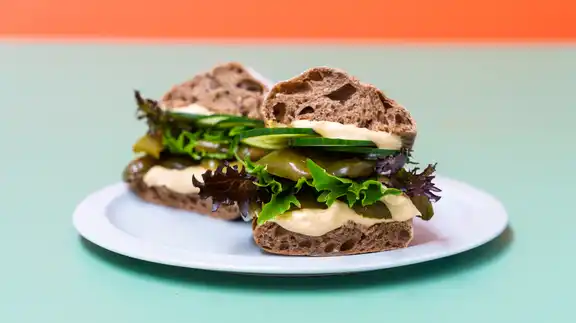 Vegansk sandwich med hummus med grillet og syltet peberfrugt
