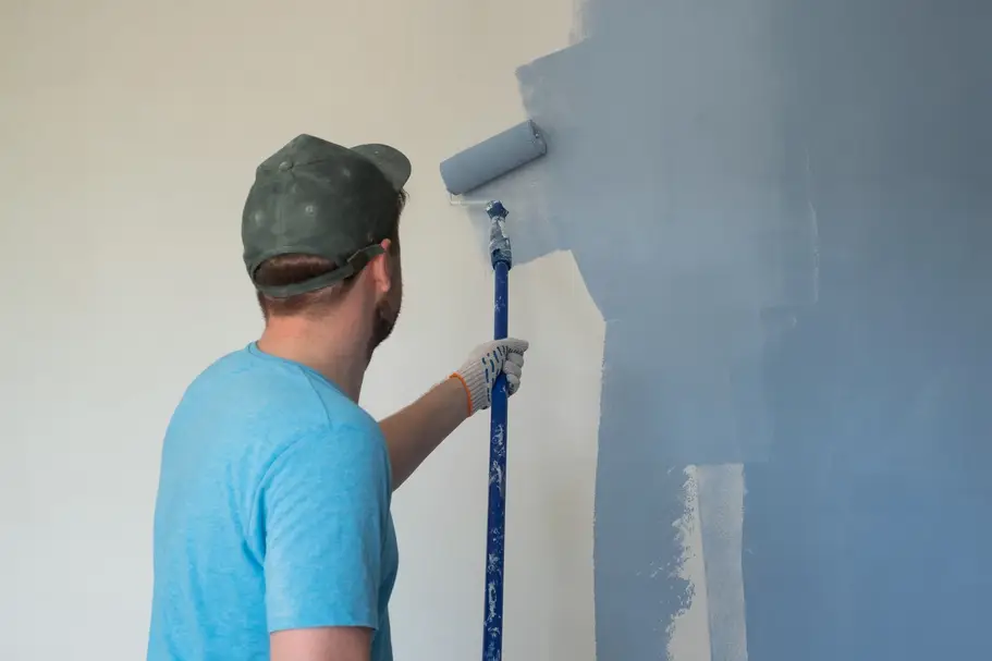 Professional painter with a paint roller on the wall